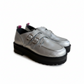 A pair of metallic silver leather double-strap loafers with chunky black lug soles, shown against a plain white background.